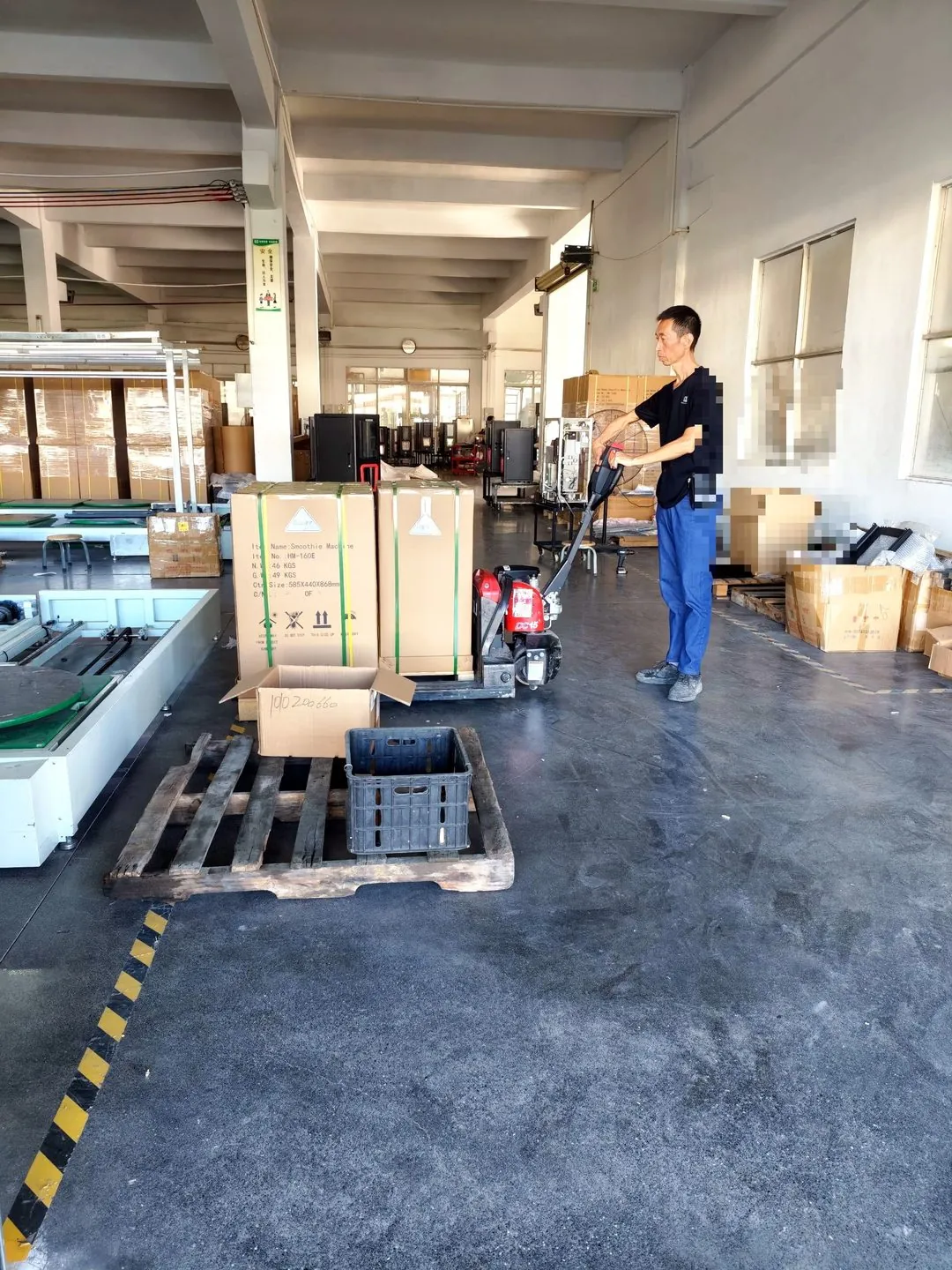 Electric pallet truck carrying HM160E cartons in the warehouse