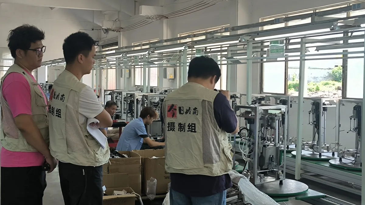Hoy Lingnan Film Crew filmando en la línea de montaje de la máquina expendedora de hommy