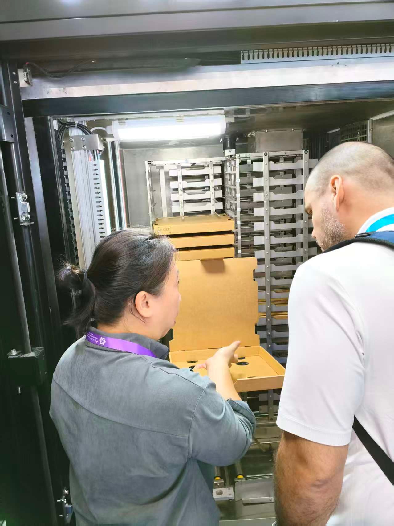 Inspecting the internal automated pizza box storage and robotic dispensing rack